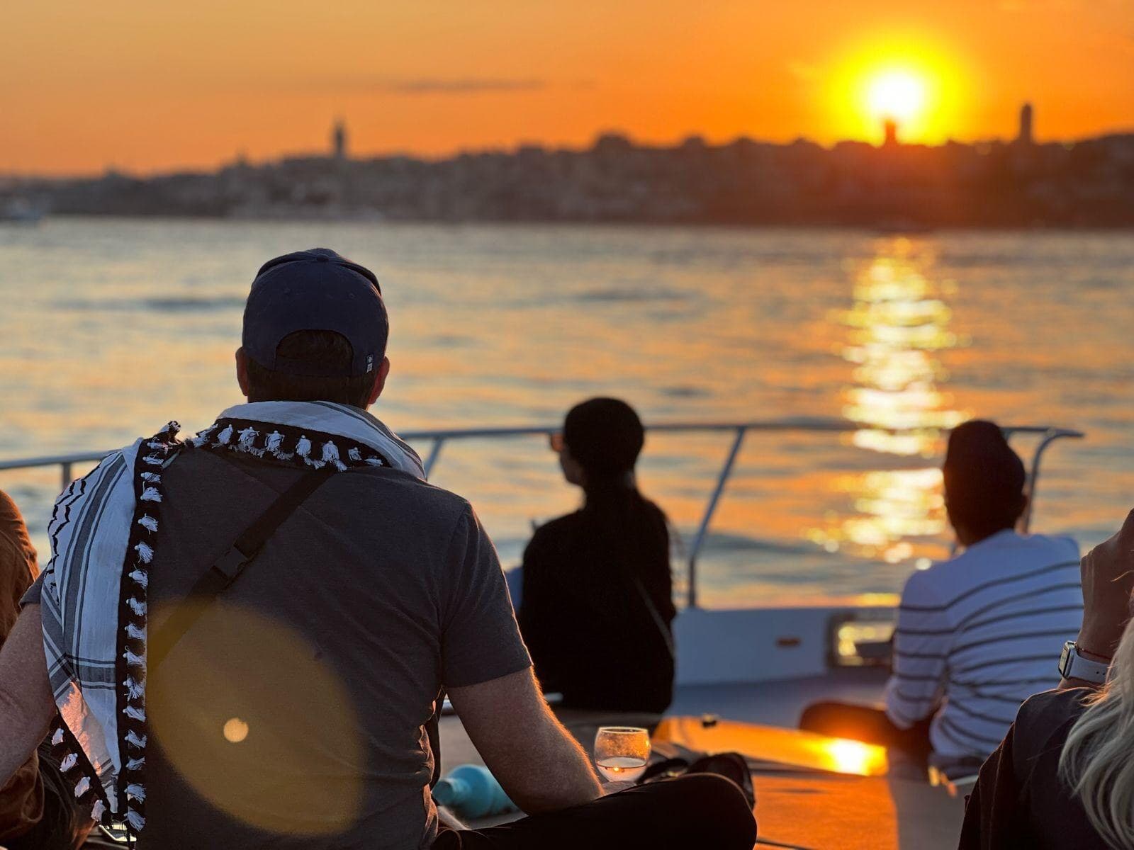 Guests seated on the aft deck watching the sun set behind the Istanbul skyline, Bosphorus